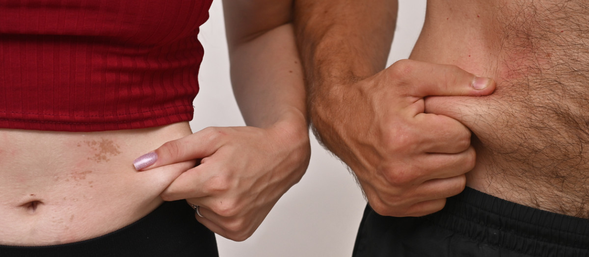 A man and a young woman measure the fat deposits on their stomachs. concept