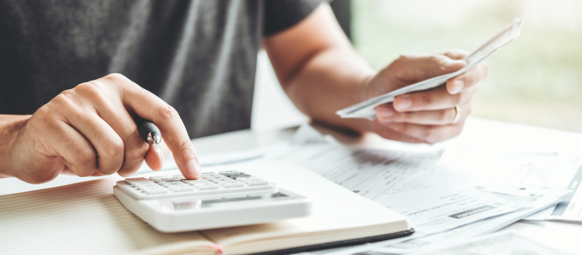 Man using calculator Accounting Calculating Cost Economic bills with money stack step growing growth saving money in home , finance concept