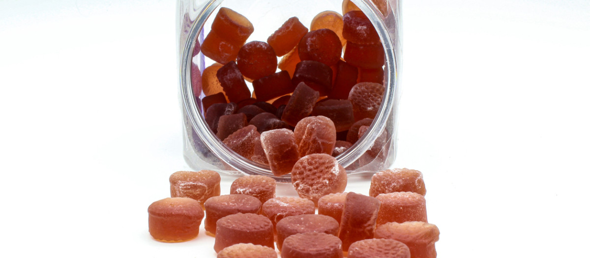 Red melatonin gummy supplements in white background.