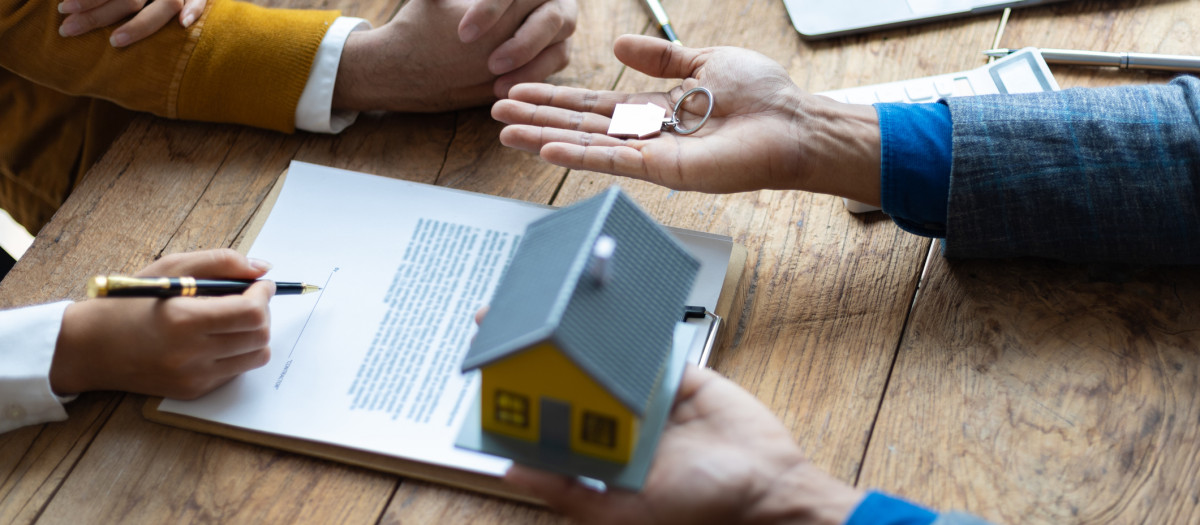 Legally signing a real estate agreement. Businessman negotiates with house sales agent before signing contract.