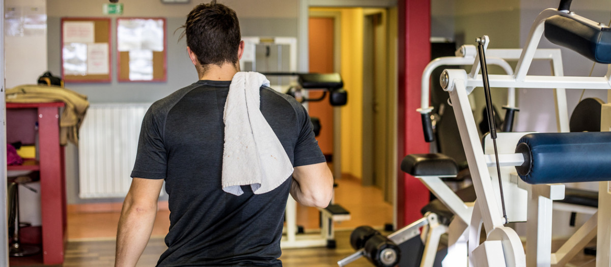 Young Man Heading For Locker Room and Shower After Training in Gym.