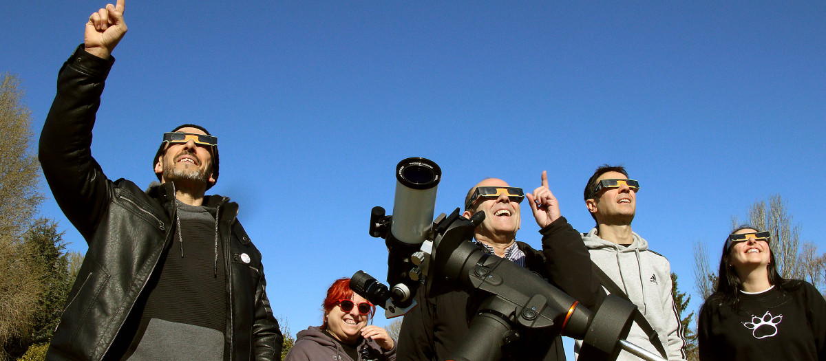 Imagen de archivo de un grupo de personas observando un eclipse parcial de sol en León