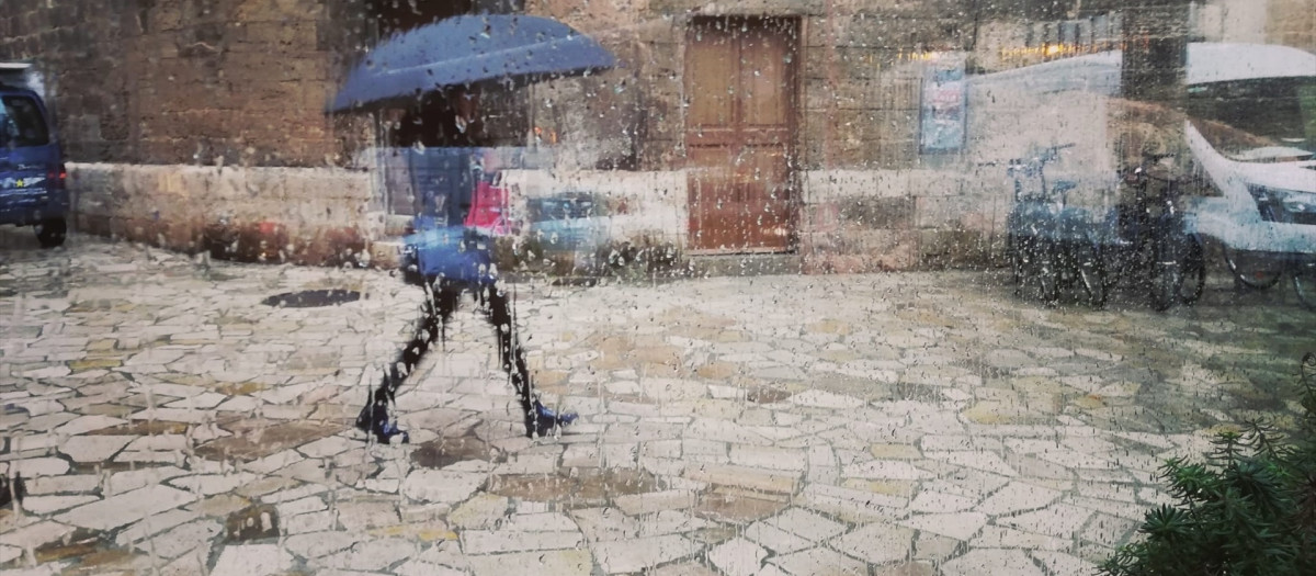 Una mujer pasea por el centro de Palma con un paraguas, vista a través de un cristal con gotas de lluvia.

EUROPA PRESS
04/12/2019