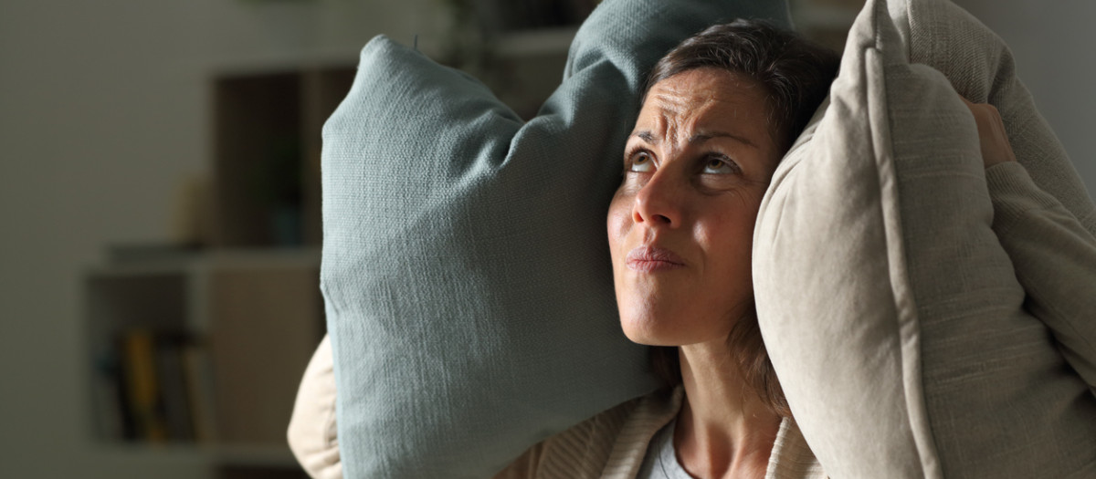 Annoyed adult woman suffering neighbour noise at night at home
