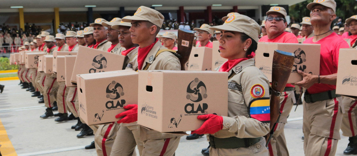 Handout photo released by Miraflores presidential palace press office showing members of the Venezuelan militia holding boxes of Local Committee for Supply and Production (CLAP) as they march in front of Venezuela's President Nicolas Maduro (out of frame) during a military parade at Los Proceres boulevard in the framework of the celebrations for Venezuela's Independence Day in Caracas, Venezuela on July 5, 2019. (Photo by HO / Venezuelan Presidency / AFP) / RESTRICTED TO EDITORIAL USE - MANDATORY CREDIT AFP PHOTO /  PRESIDENCIA VENEZUELA - NO MARKETING - NO ADVERTISING CAMPAIGNS - DISTRIBUTED AS A SERVICE TO CLIENTS