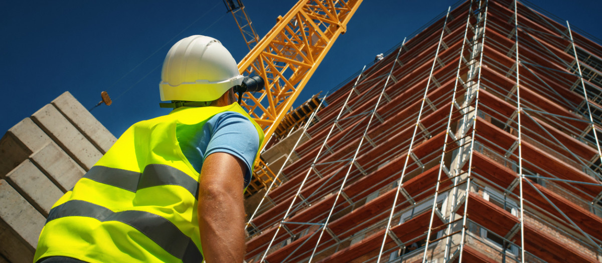 Un obrero observa la construcción de un edificio