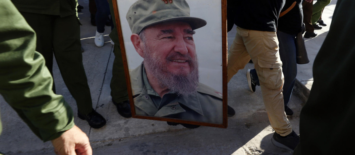 Personas sostienen un cuadro con la imagen del líder cubano Fidel Castro durante un evento en apoyo al expresidente de Cuba Raúl Castro este viernes, en La Habana (Cuba)