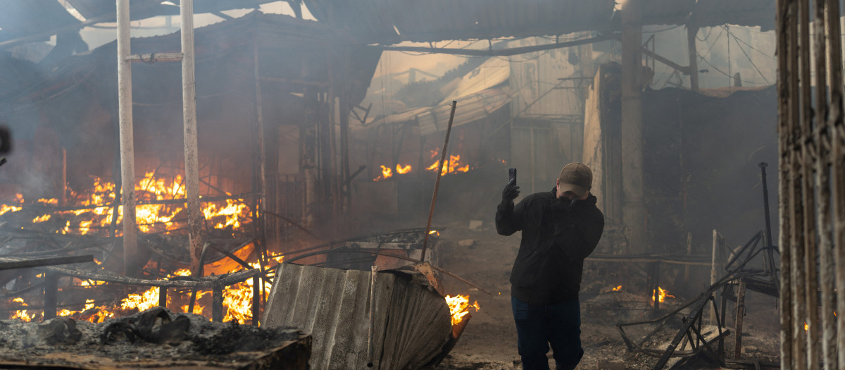 Un residente local corre entre los escombros de un edificio gravemente dañado tras los ataques rusos en Kiev