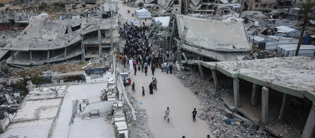 Palestinos se congregan en una calle gravemente dañada para realizar las oraciones matutinas que marcan el inicio del Eid al-