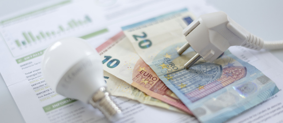 a white electric cap, a light bulb and euro banknotes on an electric bill. Increase in the cost of electricity for residential customers and business users. Payment of electricity bills. Increasing the concept of electricity prices.