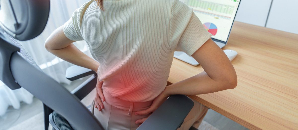 Woman having back body pain during work long time on workplace. due to Piriformis, Low Back, waist ache, lumbago, kidney, rheumatism and Spinal Compression. Office syndrome and Ergonomic concept