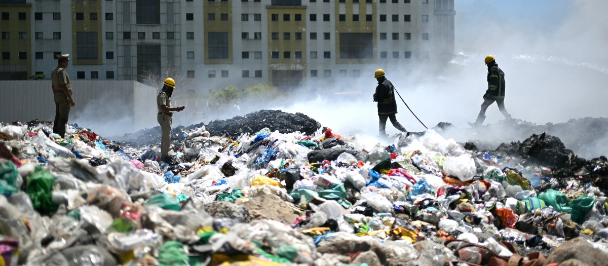 El personal de bomberos extingue un incendio en una zona de separación de escombros en Chennai