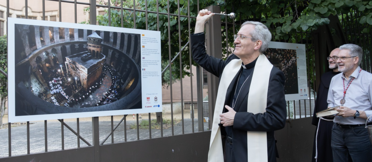 El obispo Javier Vilanova bendice una de las láminas fotográficas que conforman la muestra.