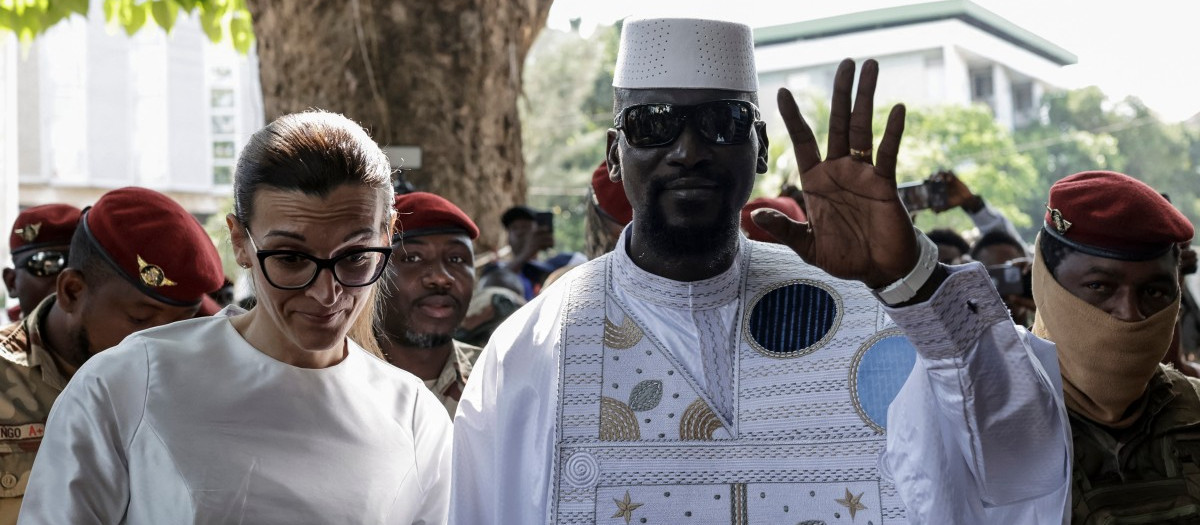 Guinea President and presidential candidate Mamady Doumbouya (CR) and his wife Lauriane Doumbouya (CL) arrive to vote at a polling station in Conakry on December 28, 2025 during Guinea's presidential election. (Photo by Patrick MEINHARDT / AFP)