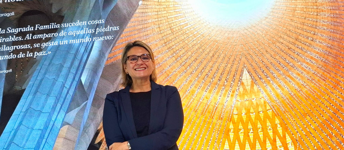 La arquitecta y experta en Antonio Gaudí, Chiara Curti, junto a una de las imágenes de la exposición
