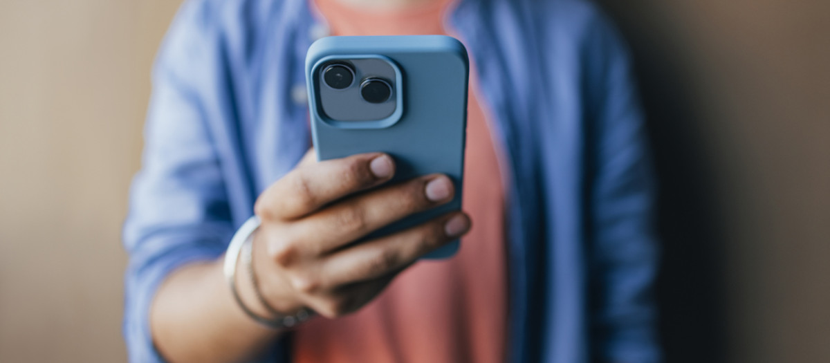 An anonymous handsome Indian male using his new smartphone to take a selfie.