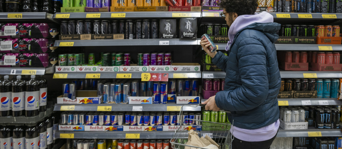 Man shopping in a supermarket while on a budget. He is looking for low prices due to inflation. He is living in the North East of England.