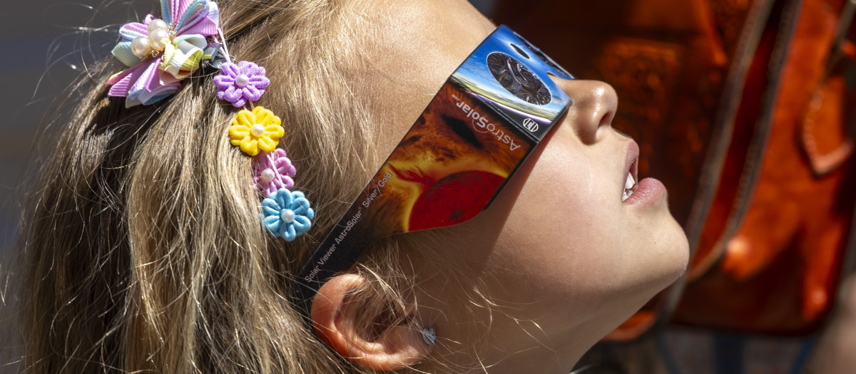 Imagen de una niña mirando un eclipse.