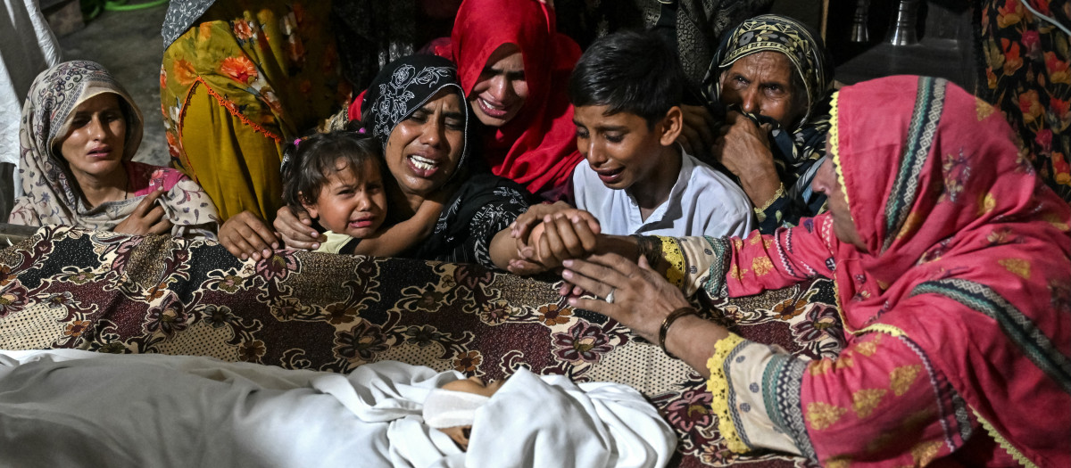 Familiares lloran junto al cuerpo de un niño fallecido, tras el derrumbe del techo de un centro de tutorías en las afueras de Lahore,