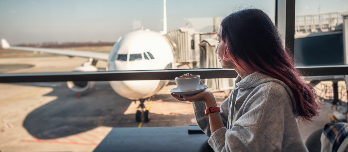 Pasajera tomando un café en un aeropuerto