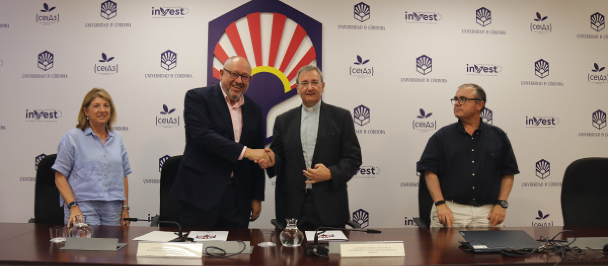 El rector y el deán estrechan sus manos tras la firma del acuerdo