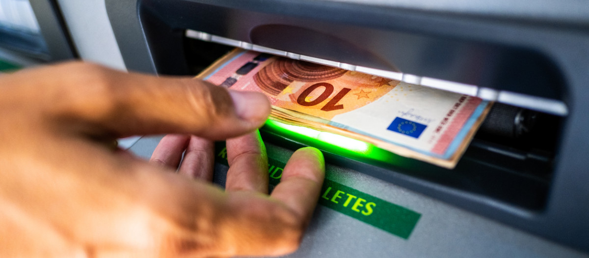 Una persona extrae dinero de un cajero automático