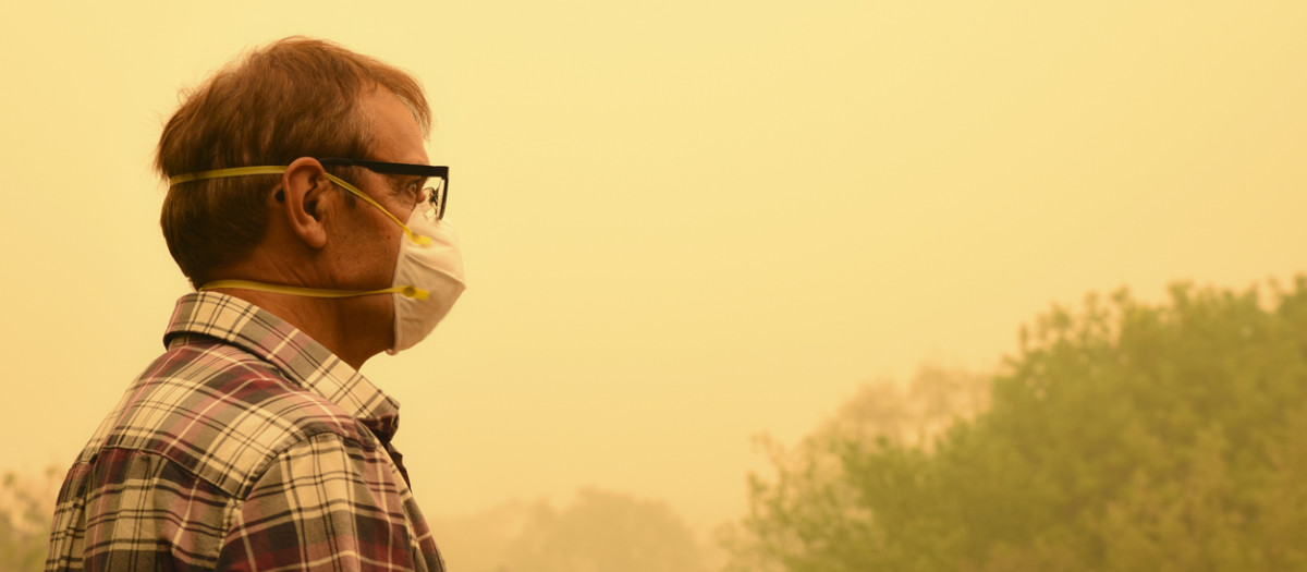 Una persona rodeada de humo de un incendio