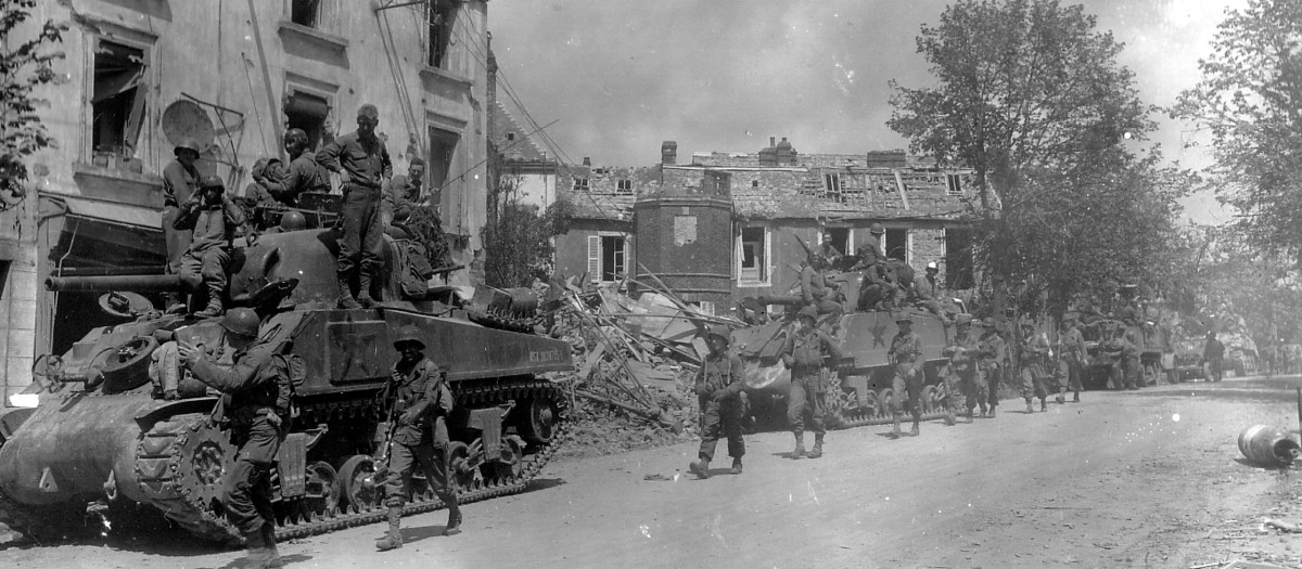 Fuerzas blindadas y de infantería estadounidenses atraviesan la devastada ciudad de Coutances, Francia, en la nueva ofensiva contra los nazis
