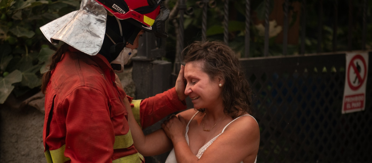 Una efectivo de la UME consuela a una vecina de Piedralaves tras quemarse la casa de su padre durante el incendio de Burgohondo