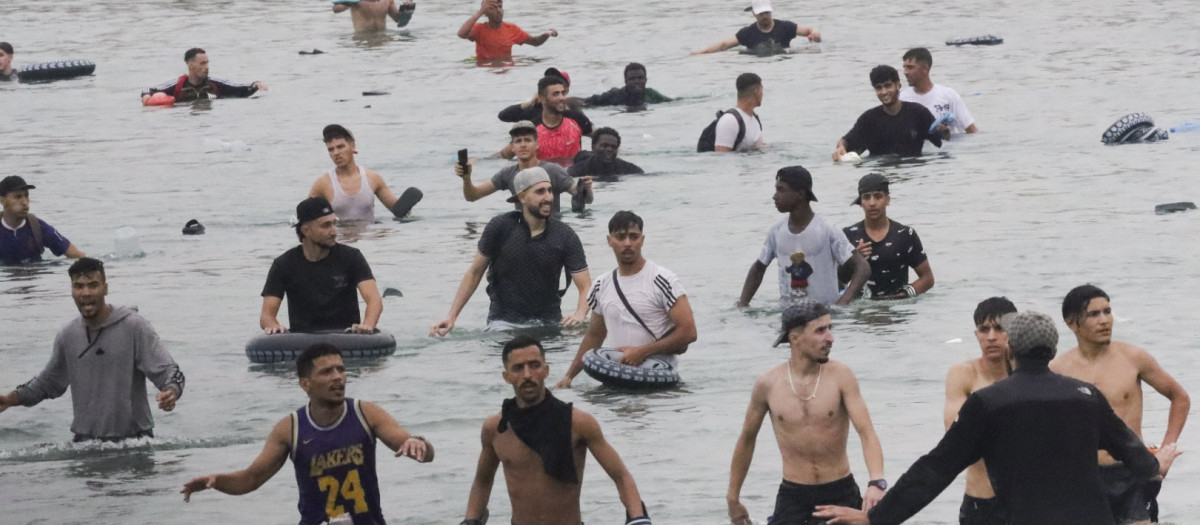 Un grupo de inmigrantes en la playa junto al paso fronterizo del Tarajal en Ceuta este viernes