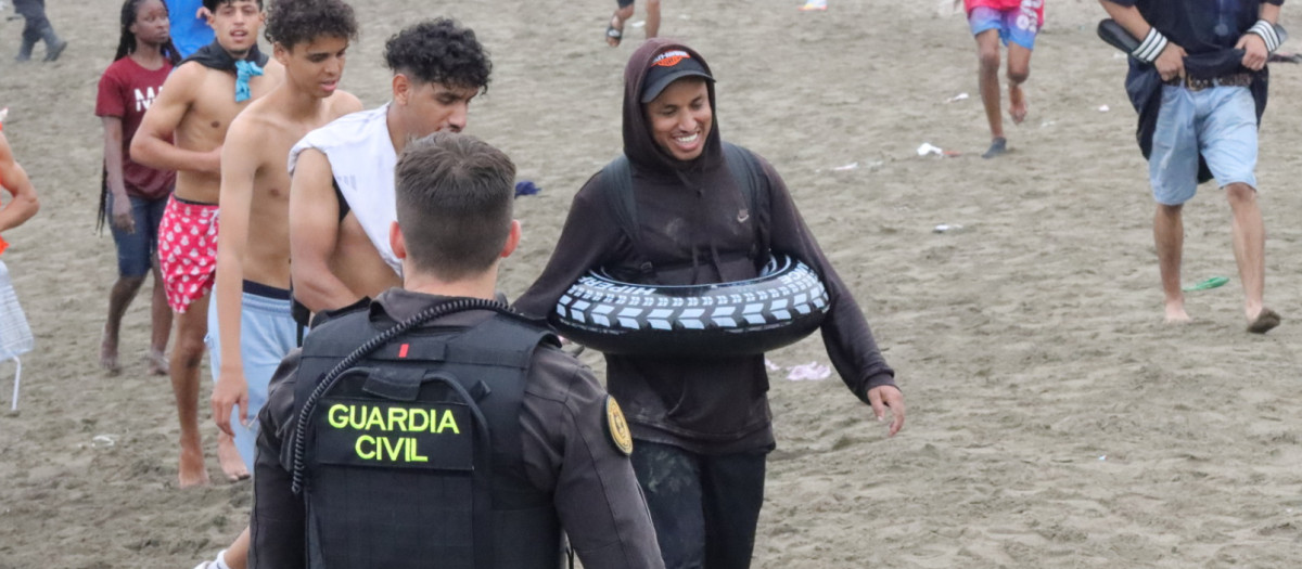 Un grupo de inmigrantes en la playa junto al paso fronterizo del Tarajal en Ceuta este viernes