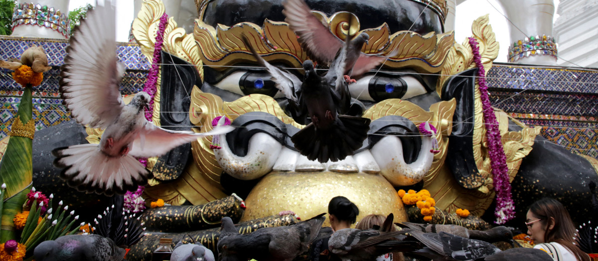 Ofrendas depositadas en un altar con una estatua de Rahu en el templo Wat Khun Chan de Bangkok, Tailandia