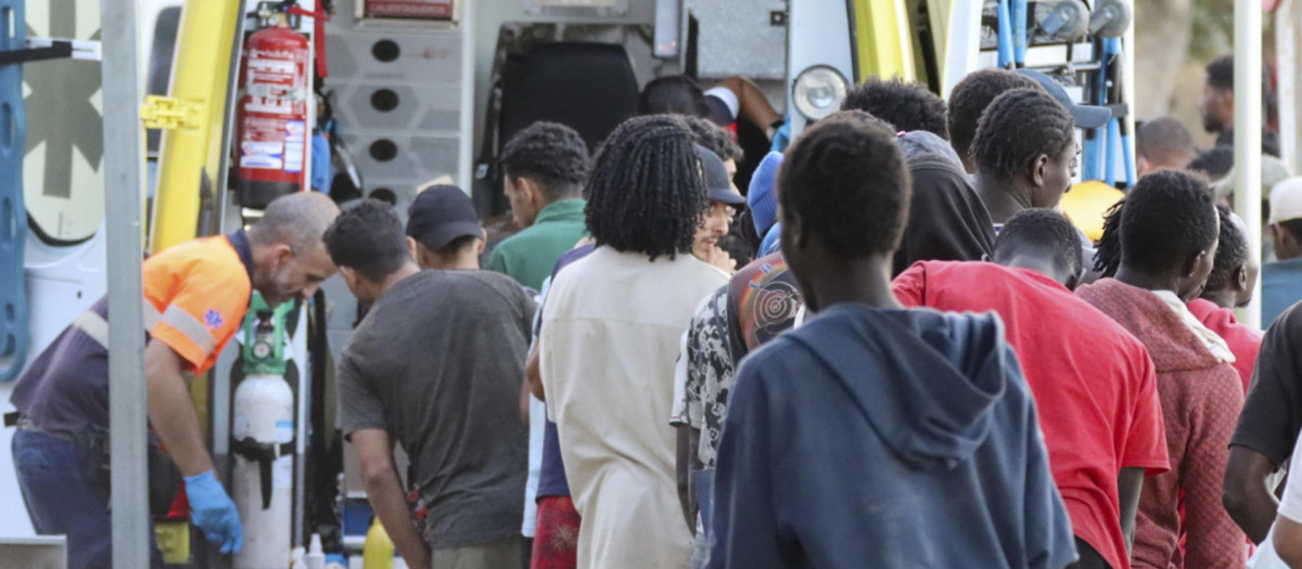 Inmigrantes hacen fila para ser atendidas por los servicios médicos este martes, en la playa El Trampolín de Ceuta