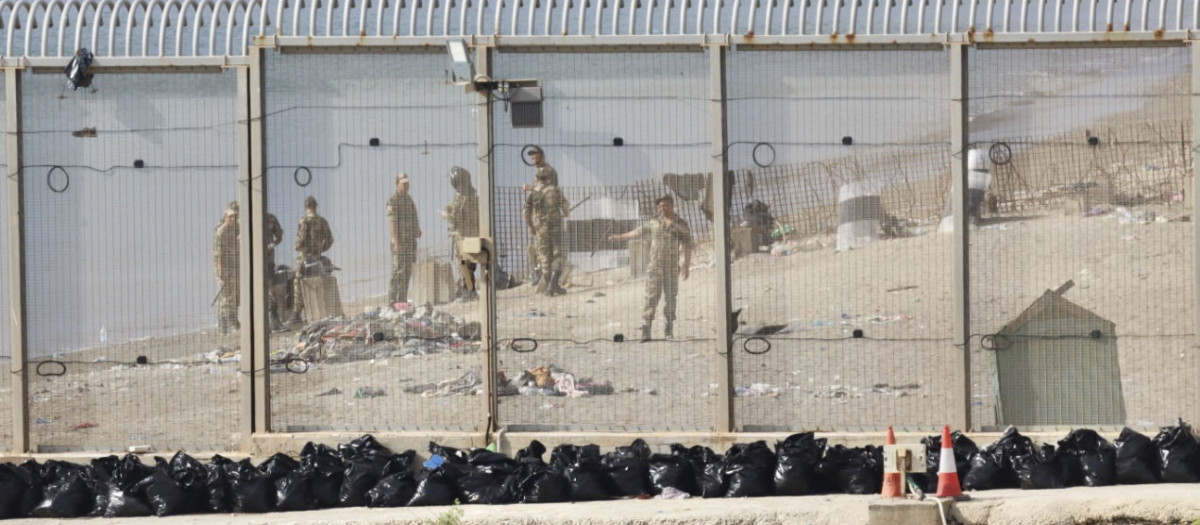Fuerzas auxiliares marroquíes vigilan este lunes la zona de la valla que separa Ceuta de Marruecos