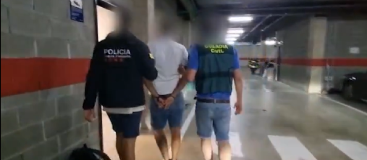 Un agente de los Mossos y un guardia civil acompañan a uno de los detenidos