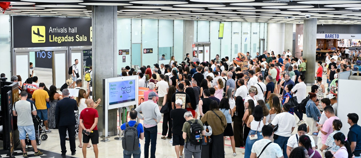 Imagen de archivo de varios viajeros en la zona de llegadas, en la T4 del aeropuerto de Barajas en Madrid