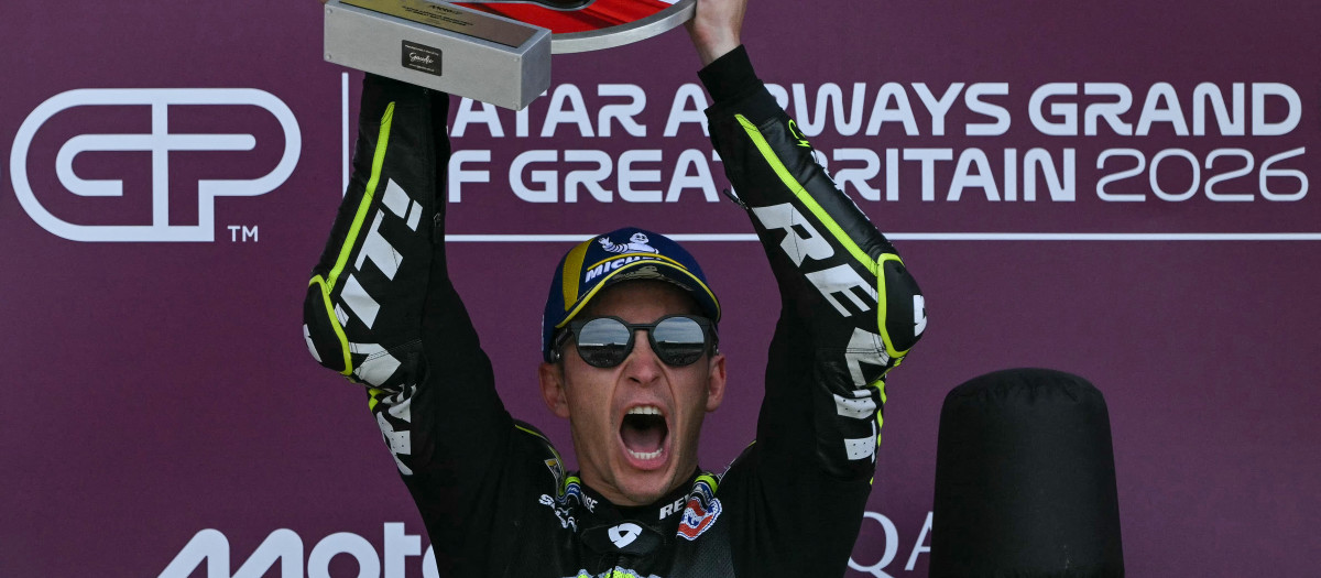 Trackhouse MotoGP's Spanish rider Raul Fernandez holds up the winner's trophy to celebrate his victory on the podium at the end of the MotoGP British Grand Prix at Silverstone circuit, central England on August 9, 2026. (Photo by Glyn KIRK / AFP)