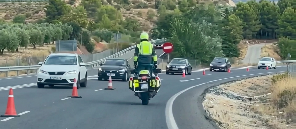 Un agente de la Guardia Civil circulando frente a una retención de coches