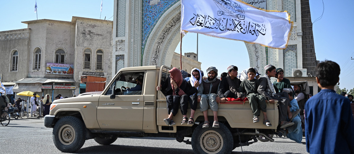 Hombres afganos con banderas del régimen talibán en una calle de Kandahar
