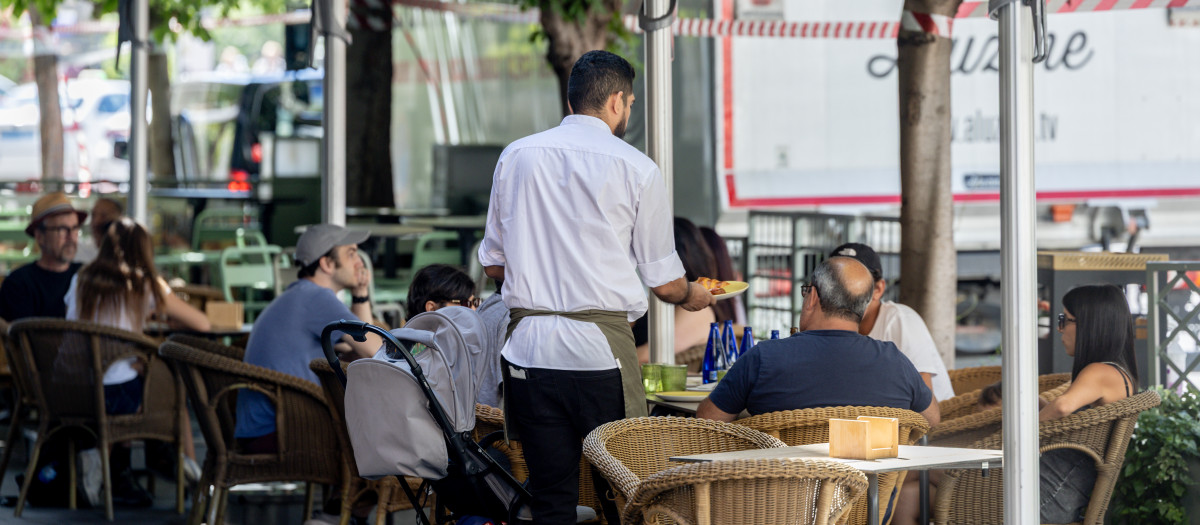 Clientes de un bar se refrescan en la terraza