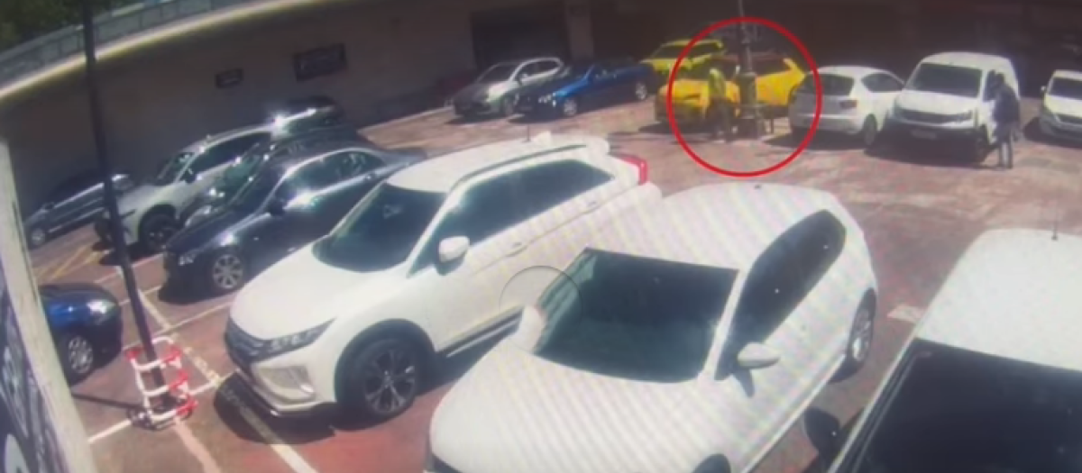 Momento en el que uno de los cómplices tira algo detrás del coche