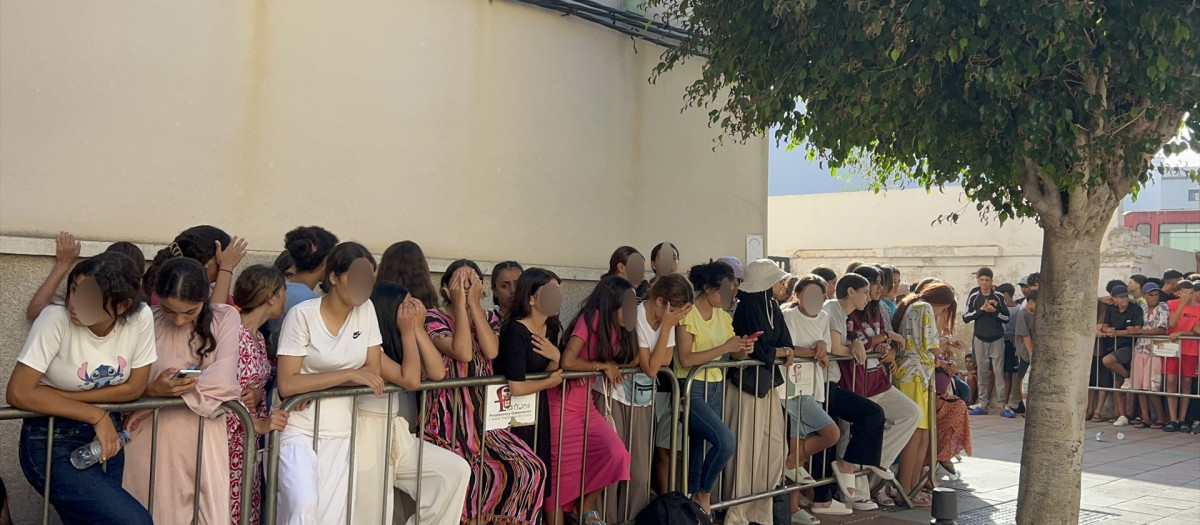 Niños y niñas esperan a las puertas de la Jefatura Superior de Policía de Ceuta para que les registren este mes de agosto