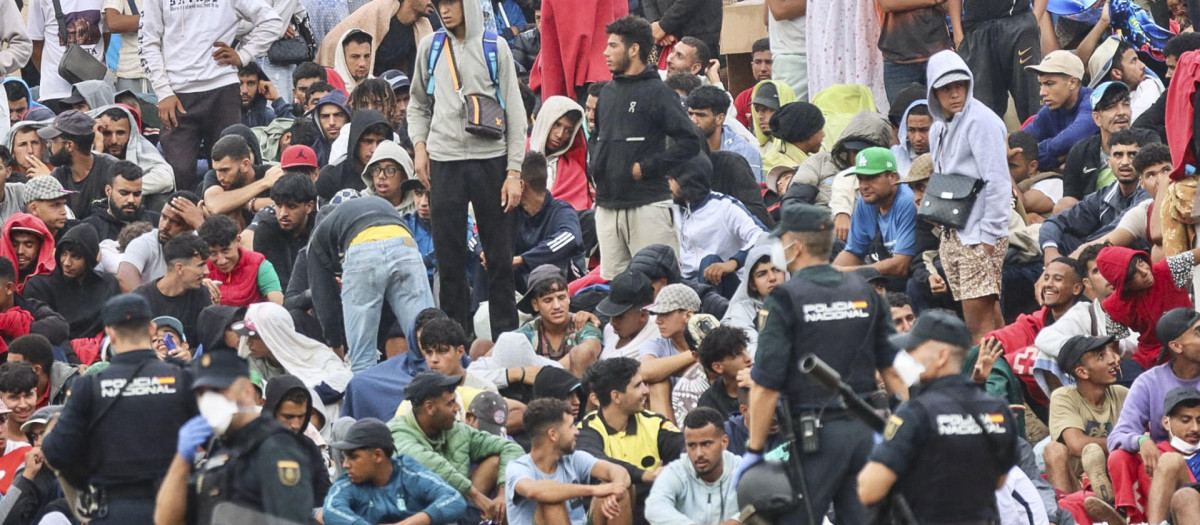 La policía vigila a inmigrantes que continúan viviendo en las inmediaciones de la playa del Trampolín en Ceuta, este viernes