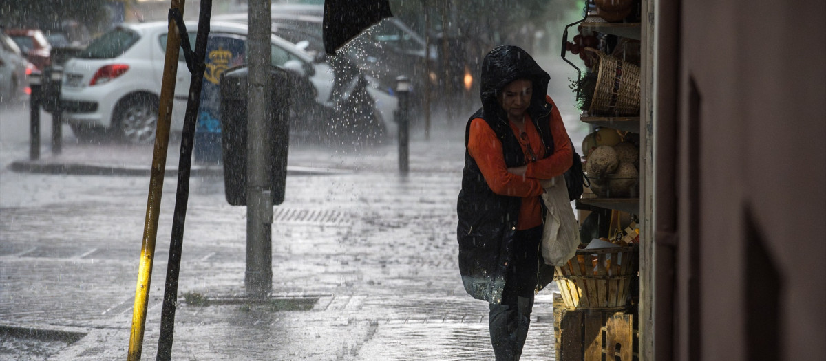 Una mujer con paraguas bajo la lluvia