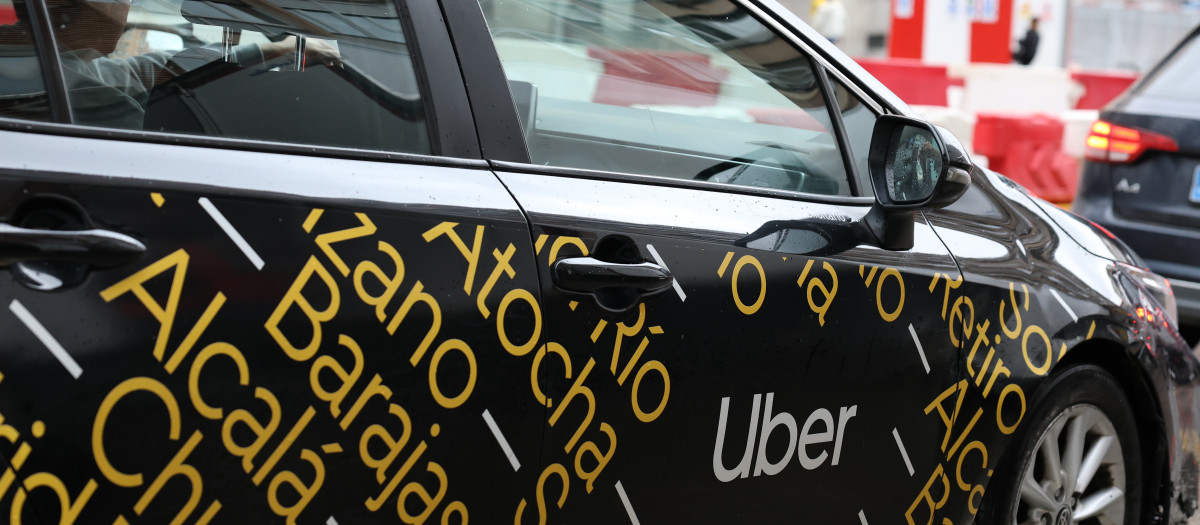 Coche Uber circula por una calle,
