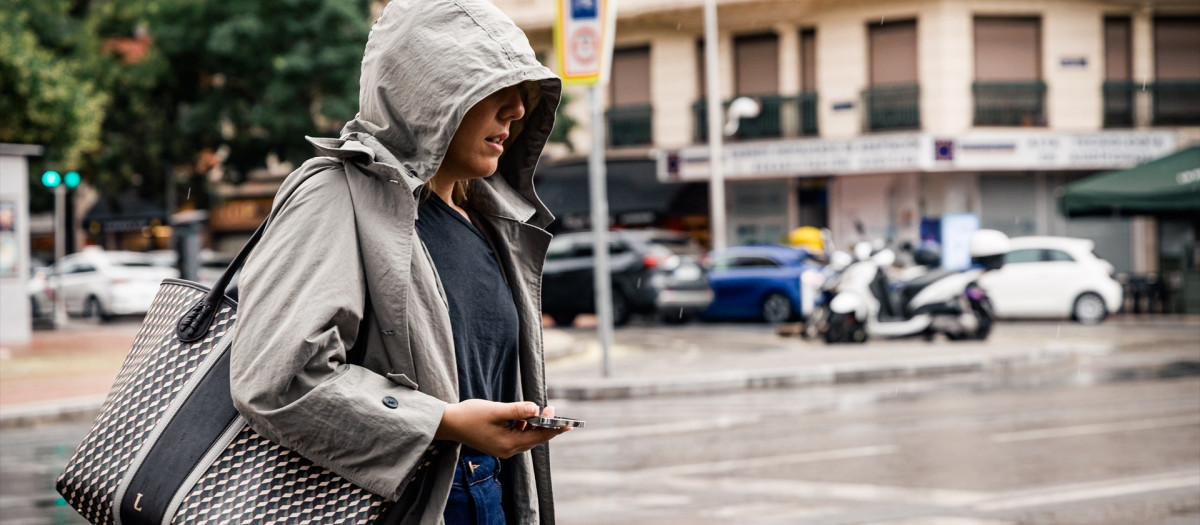 Una mujer pasea bajo la lluvia en Madrid
