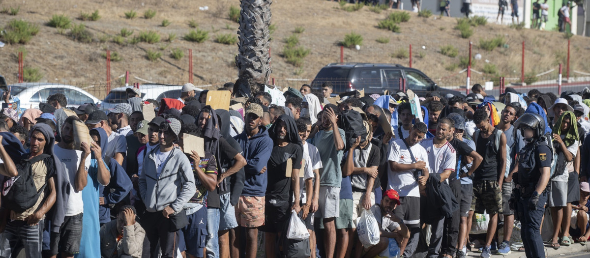 Migrantes esperan en una cola en Ceuta