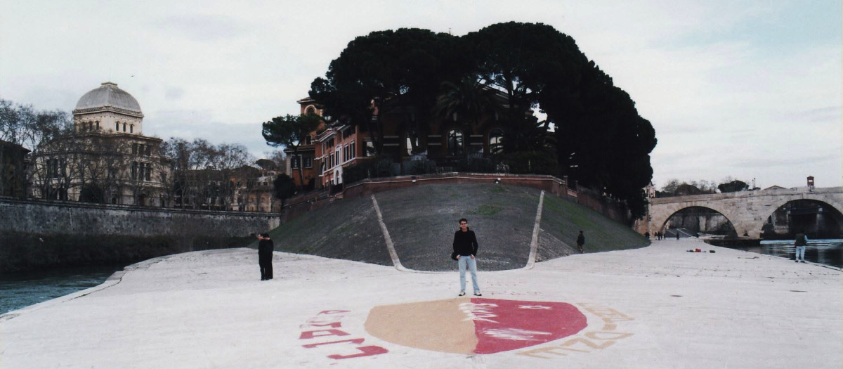 El autor, junto a un grafiti del escudo de la AS Roma en la isla del Tíber