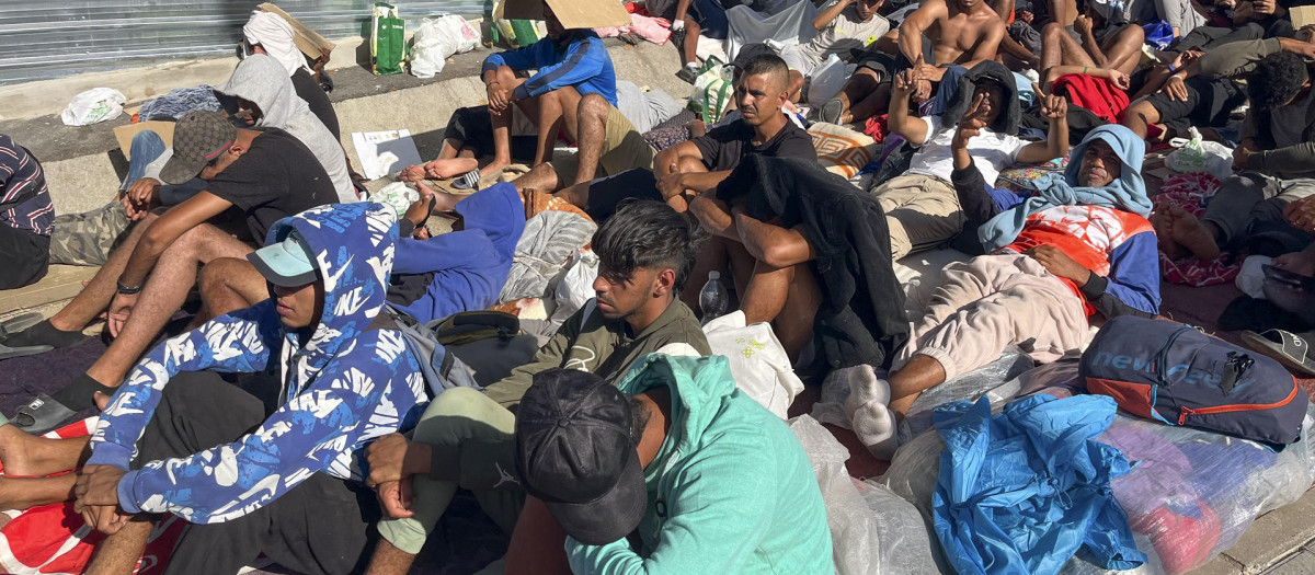 Inmigrantes aguardan este martes en los alrededores para poder acceder al centro provisional habilitado con carpas militares en la explanada de embolsamiento de ‘Loma Colmenar