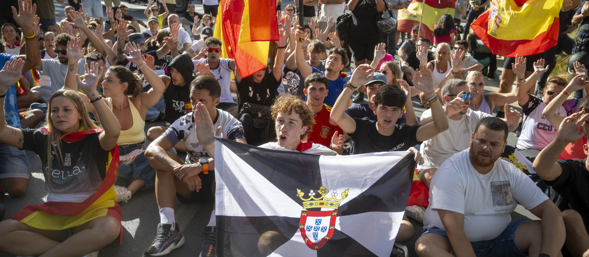 Varias personas durante una manifestación para protestar por la situación provocada por la llegada masiva de migrantes, a 27 de agosto de 2026, en Ceuta (España). Los manifestantes han tratado de impedir el acceso de los voluntarios de Cruz Roja que reparten bolsas de comida a los migrantes en la playa del Trampolín y han provocado disturbios en la playa de Benítez de Cueta, que se han saldado con cargas policiales, tras introducirse en los asentamientos de migrantes que pernoctan en la zona y causar destrozos, incluido la quema de enseres.

Marcos Moreno / Europa Press
27 AGOSTO 2026 CRISIS MIGRATORIA
27/8/2026